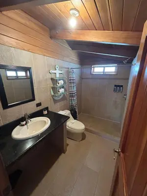 a bathroom with a sink and a toilet at Casa Aura: Beachfront Premium Hostel in Tamarindo