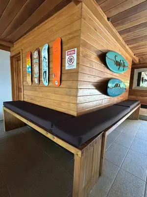 a wooden bench with surfboards on a wall at Casa Aura: Beachfront Premium Hostel in Tamarindo