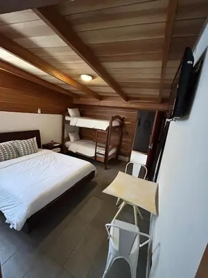 a bedroom with a bed and a tv in a room at Casa Aura: Beachfront Premium Hostel in Tamarindo