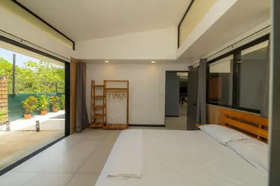 a bedroom with a large bed and a large window at Casa Tatala - 2bdr home with pool near Santa Teresa beach in Boca de Ario