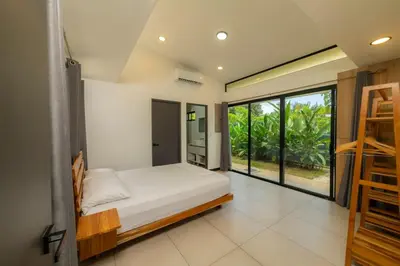 a bedroom with a bed and a large window at Casa Tatala - 2bdr home with pool near Santa Teresa beach in Boca de Ario