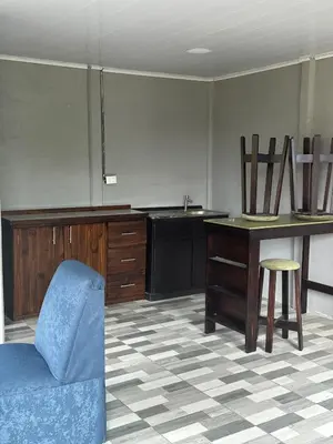 a living room with a blue chair and a table at Mi refugio in Ciudad Cortés