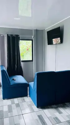a blue couch and a chair in a room at Mi refugio in Ciudad Cortés