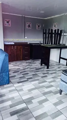 a living room with a table and chairs on a tiled floor at Mi refugio in Ciudad Cortés