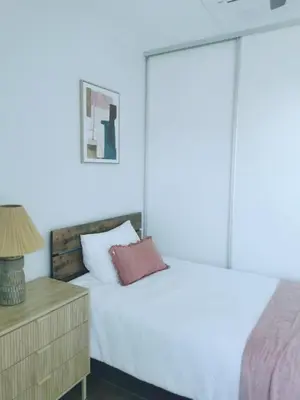 a bedroom with a white bed and a night stand at Our Paradise - Jaco Apartment in Jacó