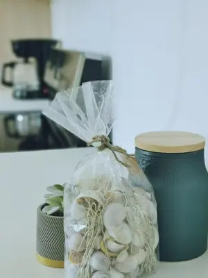 a plastic bag filled with shells sitting next to a cup at Our Paradise - Jaco Apartment in Jacó