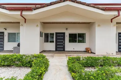 a house with black doors and green bushes at Cozy 3BR Townhouse Near Tamarindo-2 Pool&More in Santa Cruz
