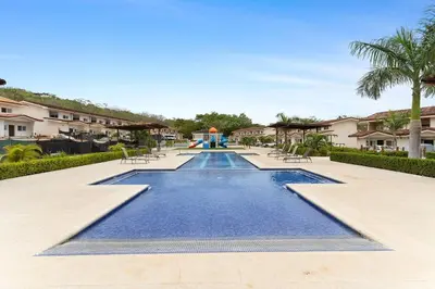 a pool at a resort with chairs and a playground at Cozy 3BR Townhouse Near Tamarindo-2 Pool&More in Santa Cruz
