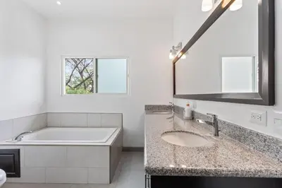 a bathroom with a sink and a tub and a mirror at Cozy 3BR Townhouse Near Tamarindo-2 Pool&More in Santa Cruz
