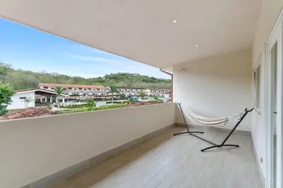 a room with a balcony with a chair and a window at Cozy 3BR Townhouse Near Tamarindo-2 Pool&More in Santa Cruz