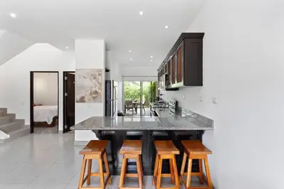 a kitchen with a large island with wooden stools at Cozy 3BR Townhouse Near Tamarindo-2 Pool&More in Santa Cruz