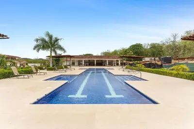 a swimming pool with chairs and a house at Cozy 3BR Townhouse Near Tamarindo-2 Pool&More in Santa Cruz