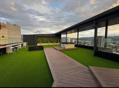 an outdoor patio with green grass on a building at Chic Studio in Barrio Escalante in Tapantí