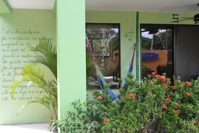 a building with flowers and plants in front of it at Mavi Surf Hotel Dominical in Dominical