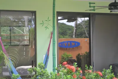 a yard sign on the side of a building with flowers at Mavi Surf Hotel Dominical in Dominical