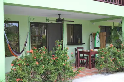 a house with a patio with a table and chairs at Mavi Surf Hotel Dominical in Dominical