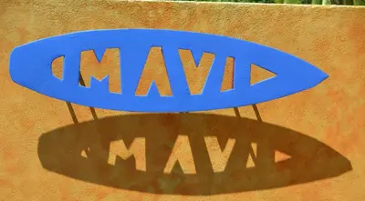 a blue sign on a wall with a shadow at Mavi Surf Hotel Dominical in Dominical