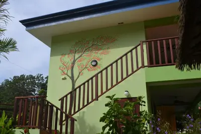 a building with a tree painted on the side of it at Mavi Surf Hotel Dominical in Dominical