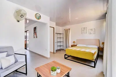 a bedroom with a bed and a couch and a table at Modern Caribbean Studio - Roosevelt in Puerto Limón
