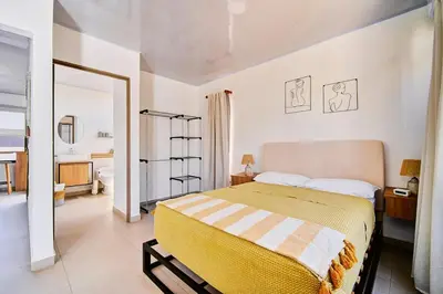 a bedroom with a large bed and a bathroom at Modern Caribbean Studio - Roosevelt in Puerto Limón