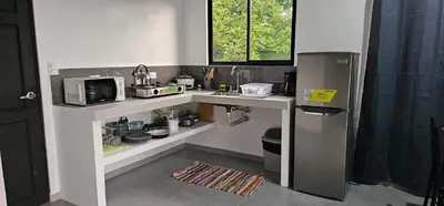 a kitchen with a counter with a microwave and a refrigerator at Casa Eden Near Manuel Antonio in Manuel Antonio