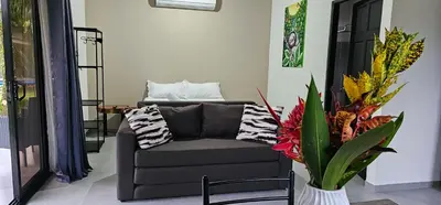 a living room with a couch and a vase with flowers at Casa Eden Near Manuel Antonio in Manuel Antonio
