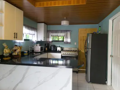 a kitchen with a black refrigerator and a stove at Marlin Vacations Home in Savegre