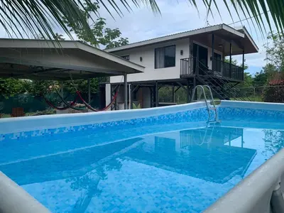 a swimming pool in front of a house at Marlin Vacations Home in Savegre
