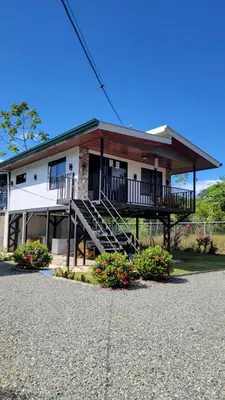 a building with a porch and stairs in front of it at Marlin Vacations Home in Savegre
