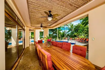 a living room with a long wooden table with red chairs at Palacio Tropical in Puntarenas
