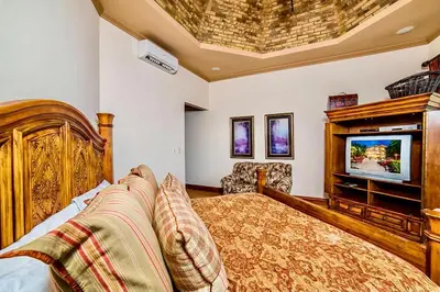 a bedroom with a bed and a flat screen tv at Palacio Tropical in Puntarenas