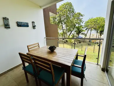a dining room with a wooden table and chairs at Beachfront Getaway, AC, Pools and Sunset Views in Bejuco
