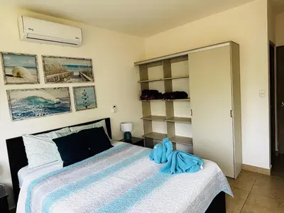 a bedroom with a bed with a blue towel on it at Beachfront Getaway, AC, Pools and Sunset Views in Bejuco