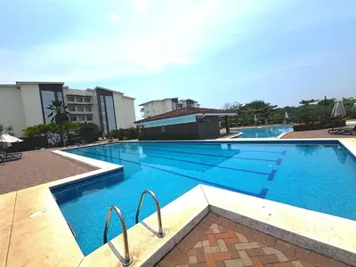 a large swimming pool with blue water in a building at Beachfront Getaway, AC, Pools and Sunset Views in Bejuco