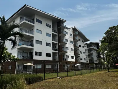 an apartment building with a fence in front of it at Beachfront Getaway, AC, Pools and Sunset Views in Bejuco