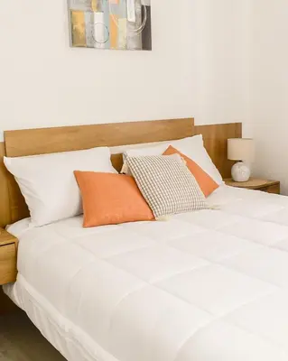 a large white bed with orange pillows on it at Gaia Retreat - Núcleo Sabana in San José