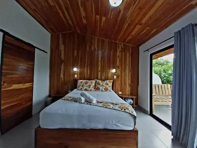 a bedroom with a large bed with a wooden ceiling at Belcruz family lodge in Monteverde Costa Rica
