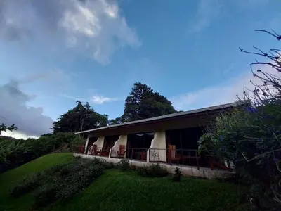 a house on a hill next to a grass field at Belcruz family lodge in Monteverde Costa Rica