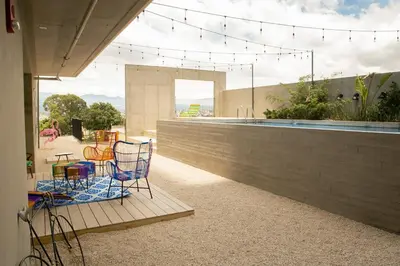 a patio with chairs and a table and a pool at Vista Aqua Escalante in San José