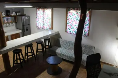 a kitchen with a counter and a bar with stools at Brisas del Caribe 3 in Tapantí
