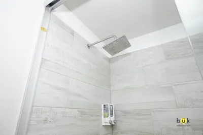 a bathroom with a shower with white tile at Catorce Urbano in San José