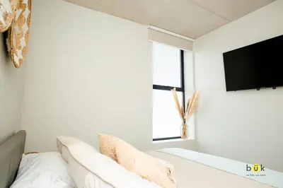 a living room with a white couch and a flat screen tv at Catorce Urbano in San José