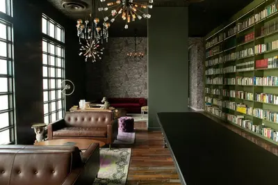 a library with a couch and a chandelier and books at Horizonte 28 Escalante in San José