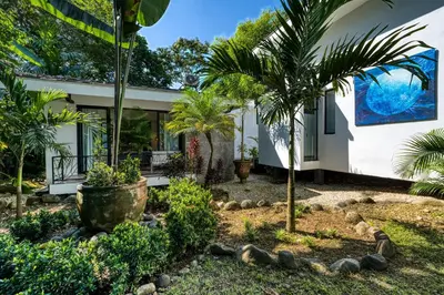 a house with palm trees in front of it at Synergy Costa Rica in Uvita
