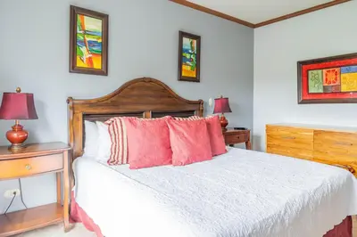 a bedroom with a white bed with red pillows at Casa del Mar - Veranda Retreat Pool and Balcony in Herradura