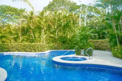 a blue swimming pool with a chair next to it at Casa del Mar - Veranda Retreat Pool and Balcony in Herradura