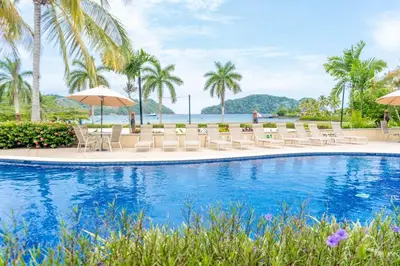 a pool at the resort with chairs and umbrellas at Casa del Mar - Veranda Retreat Pool and Balcony in Herradura