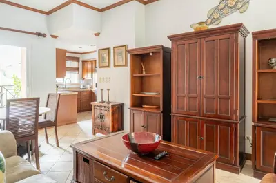 a living room with wooden cabinets and a table at Casa del Mar - Veranda Retreat Pool and Balcony in Herradura