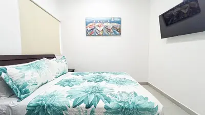 a bedroom with a bed with blue and white sheets at Macaw House with private pool in Arenas Herradura in Herradura