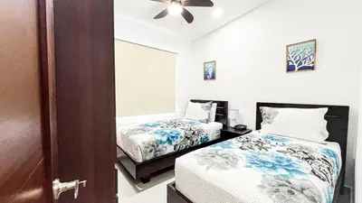 a bedroom with two beds and a ceiling fan at Macaw House with private pool in Arenas Herradura in Herradura